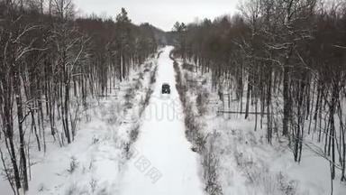 6x6越野车的鸟瞰图，在冬季森林的雪覆盖道路上，正面可见风景